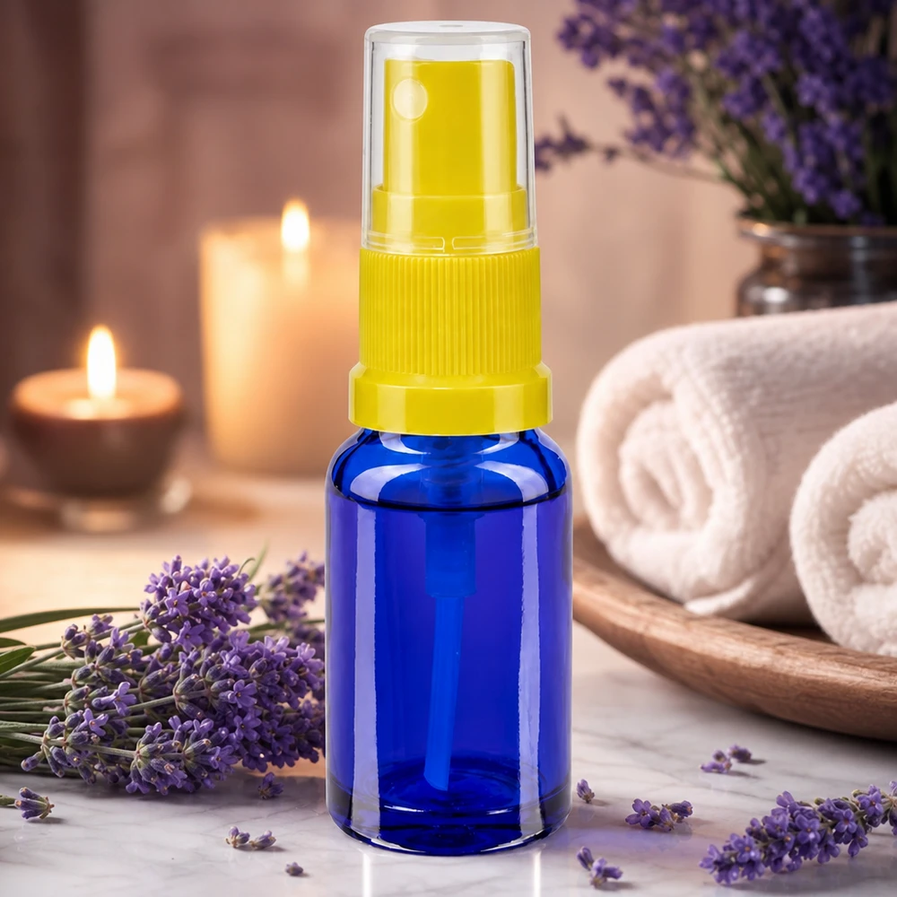 Flacon de pharmacie bleu 30ml embout spray jaune Accessoire d'aromathérapie : flacon vaporisateur bleu de 30 ml avec embout jaune, à côté de fleurs de lavande