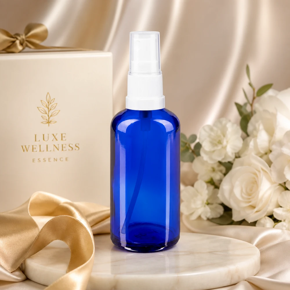 Flacon en verre bleu cobalt de 50 ml muni d'un vaporisateur blanc, sur fond d'élégant coffret cadeau