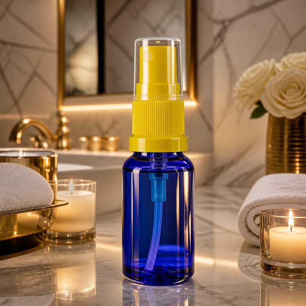 Petit flacon vaporisateur en verre bleu de 30 ml avec une pompe jaune sur fond marbré