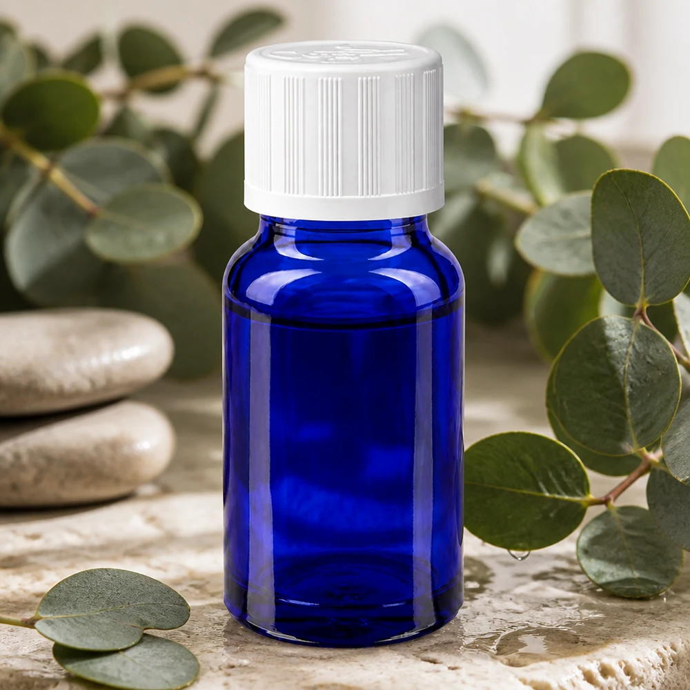 Flacon de pharmacie bleu 10 ml avec bouchon vissable blanc avec sécurité enfant standard Flacon de pharmacie bleu de 10 ml muni d'un bouchon de sécurité blanc pour enfants, posé parmi des branches d'eucalyptus