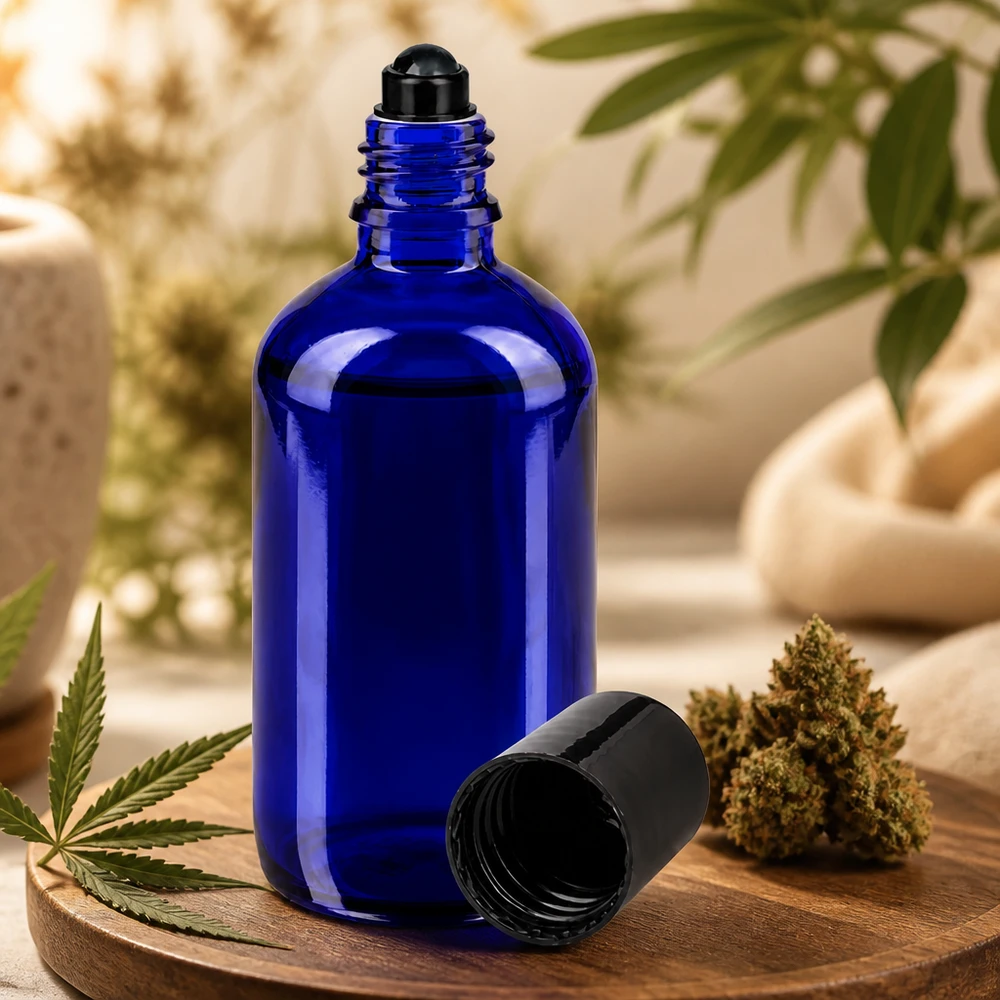 Flacon de déodorant en verre bleu 100 ml, déo à bille vide Flacon roll-on bleu de 100 ml en verre d'apothicaire, à côté d'une fleur de cannabis et d'une feuille de chanvre, posé sur une planche en bois