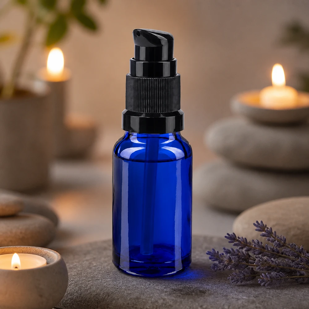 Flacon en verre de pharmacie bleu de 10 ml muni d'un bouchon-pompe noir, à côté de lavande et de bougies