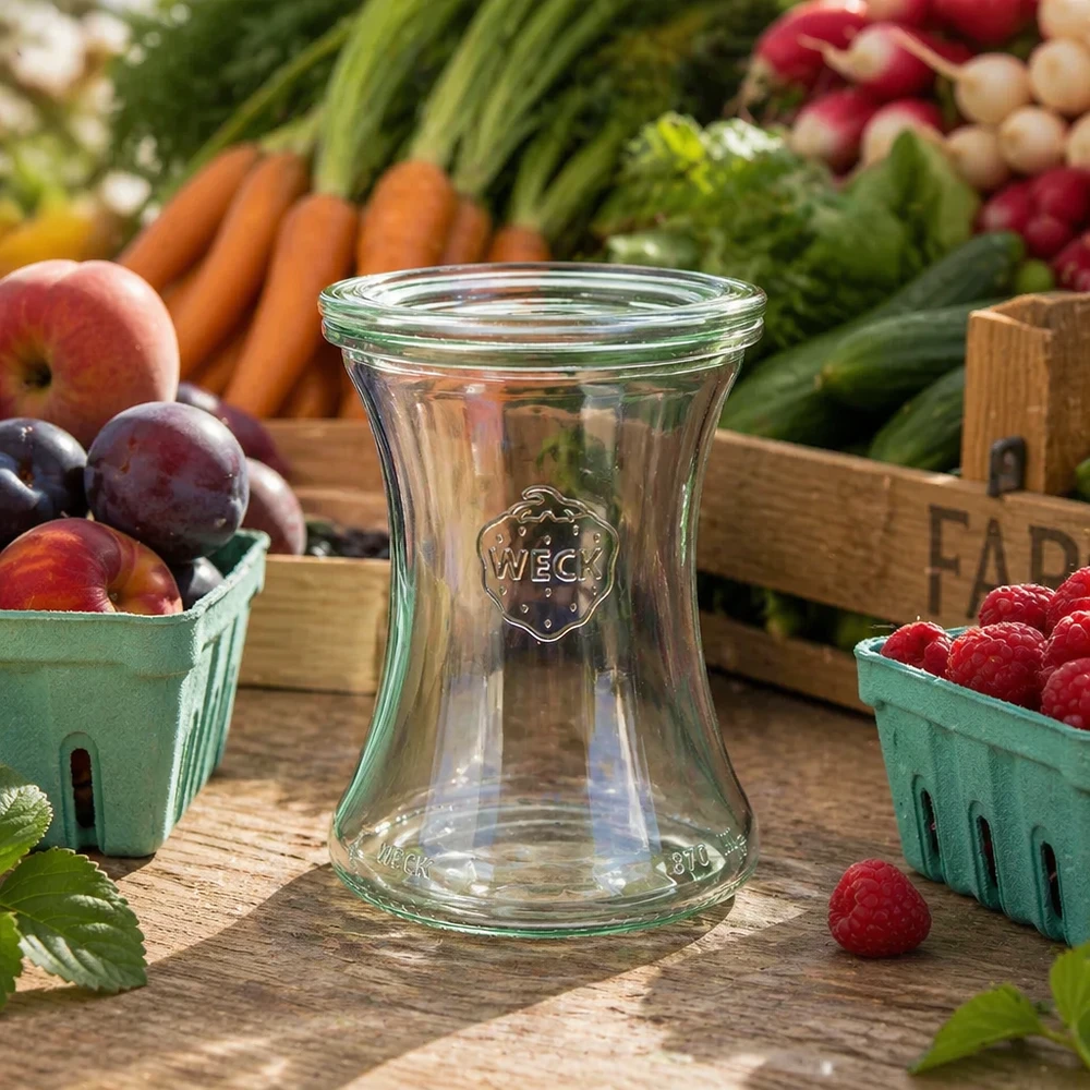 WECK Pot d'épicerie fine 370ml RR80 vide sur table en bois parmi les fruits et légumes frais montre une utilisation naturelle