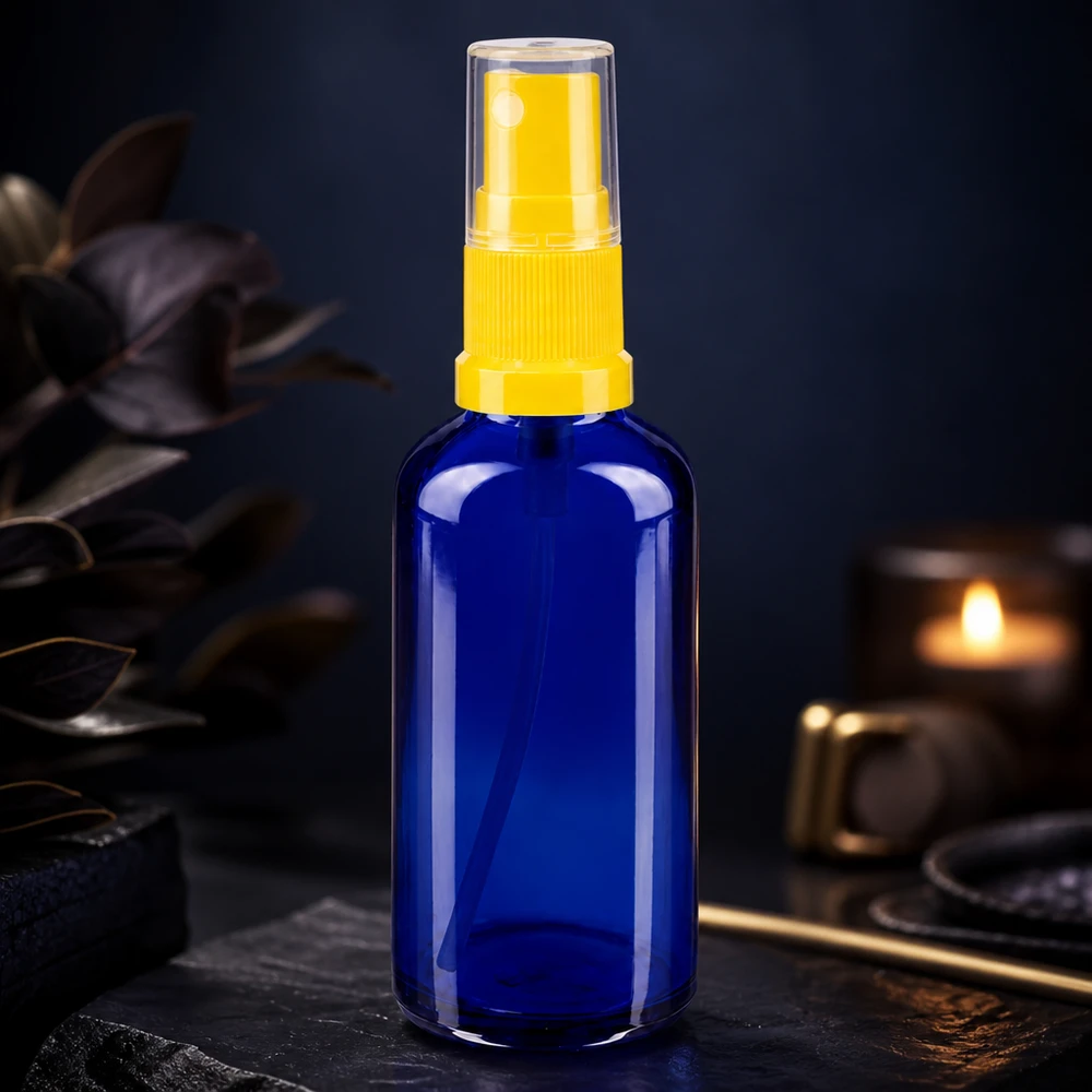 Flacon pulvérisateur en verre bleu de 50 ml, de type pharmacie, muni d'un diffuseur jaune, sur fond sombre