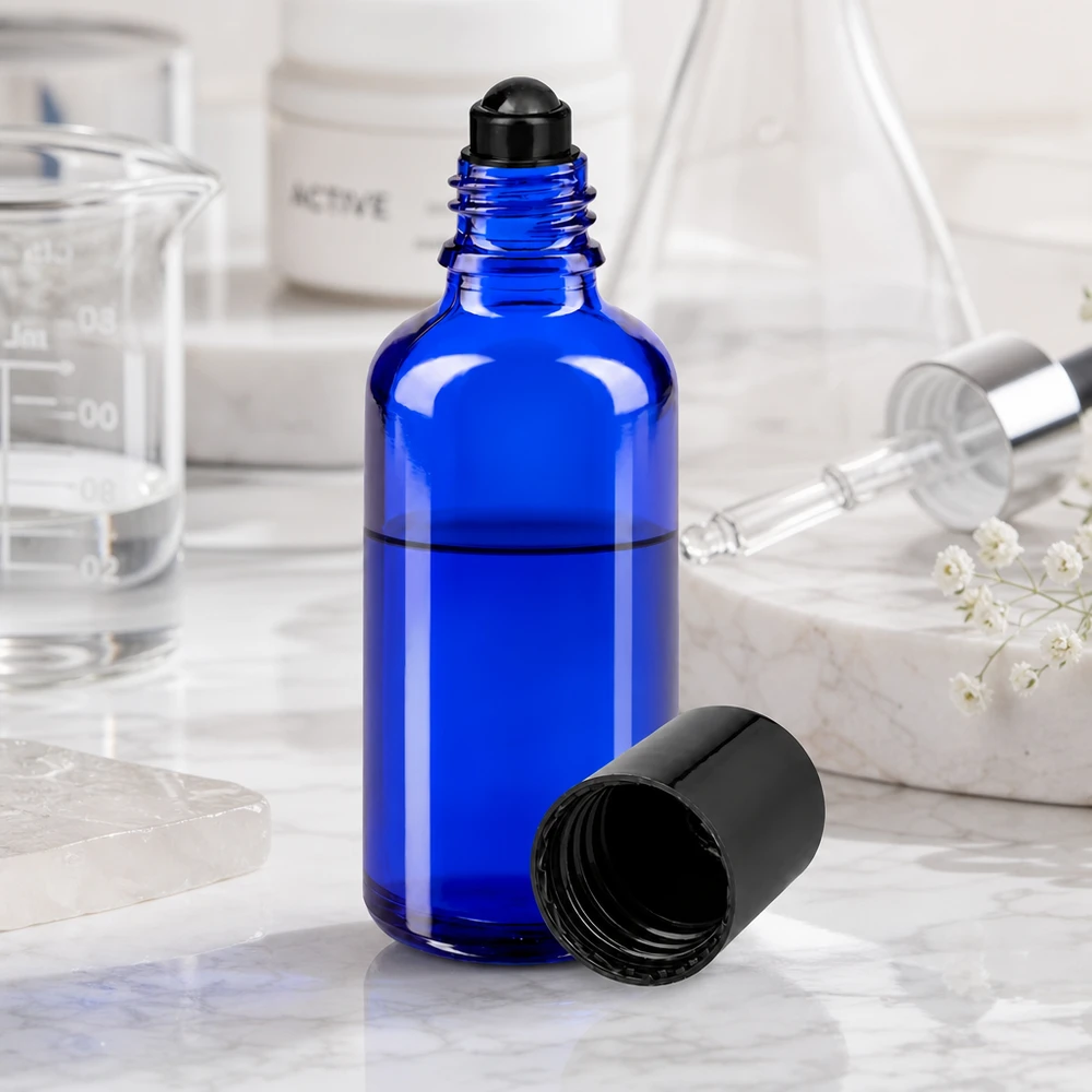 Flacon de déodorant en verre bleu 50 ml, déo à bille vide Flacon roll-on de 50 ml bleu cobalt avec bouchon à vis noir, à côté d'un bécher en verre et d'une pipette