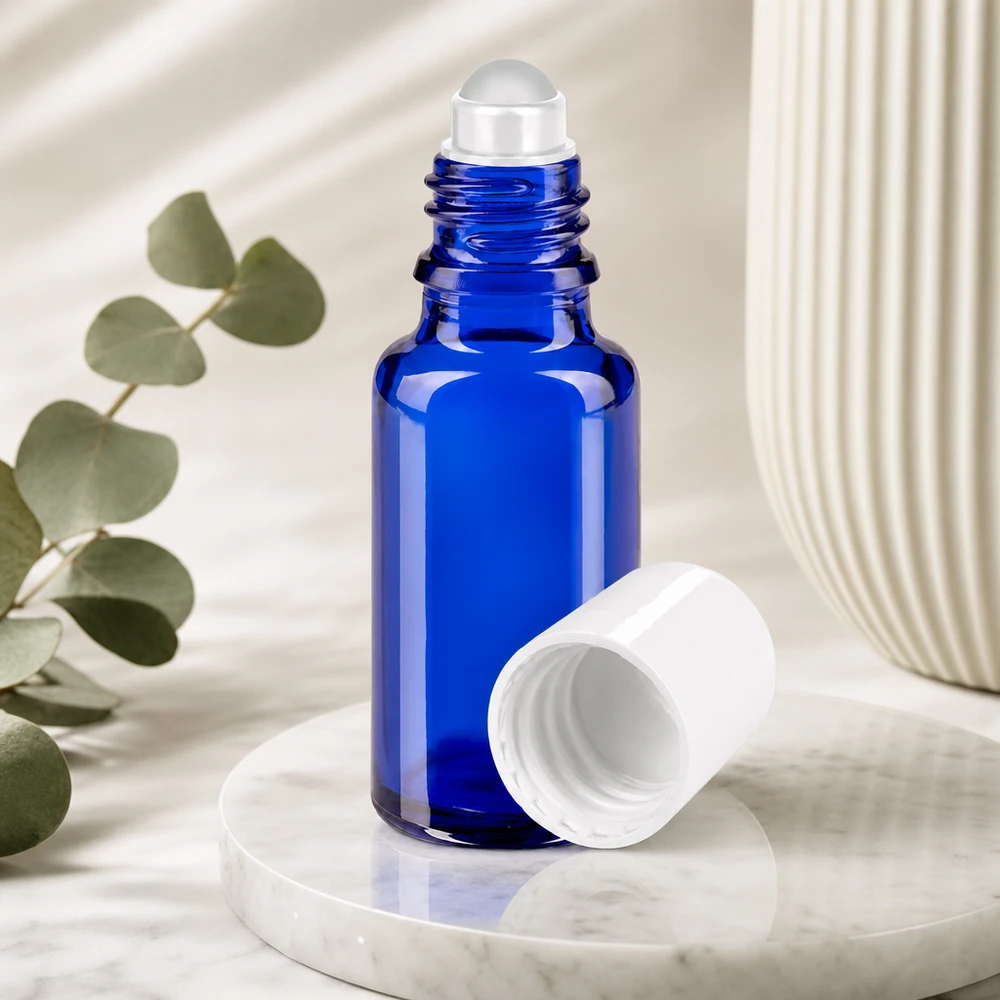 Flacon roll-on bleu de 20 ml en verre de pharmacie, avec son bouchon blanc retiré, posé sur du marbre