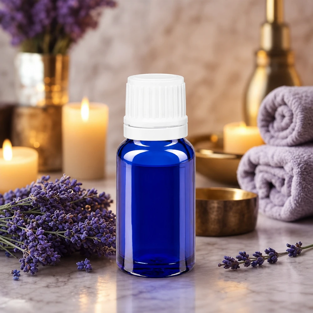 Flacon en verre bleu de 10 ml muni d'un compte-gouttes, entouré de fleurs de lavande et de bougies
