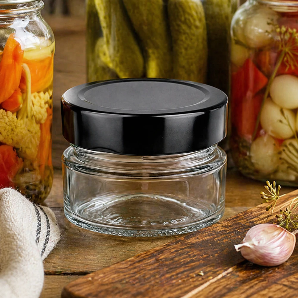 80ml Verre rond avec couvercle BasicSeal noir UNiTWIST Bocal rond BasicSeal 80ml noir UNiTWIST Scène de cuisine Bocaux Planche en bois Ail Aneth Conservation