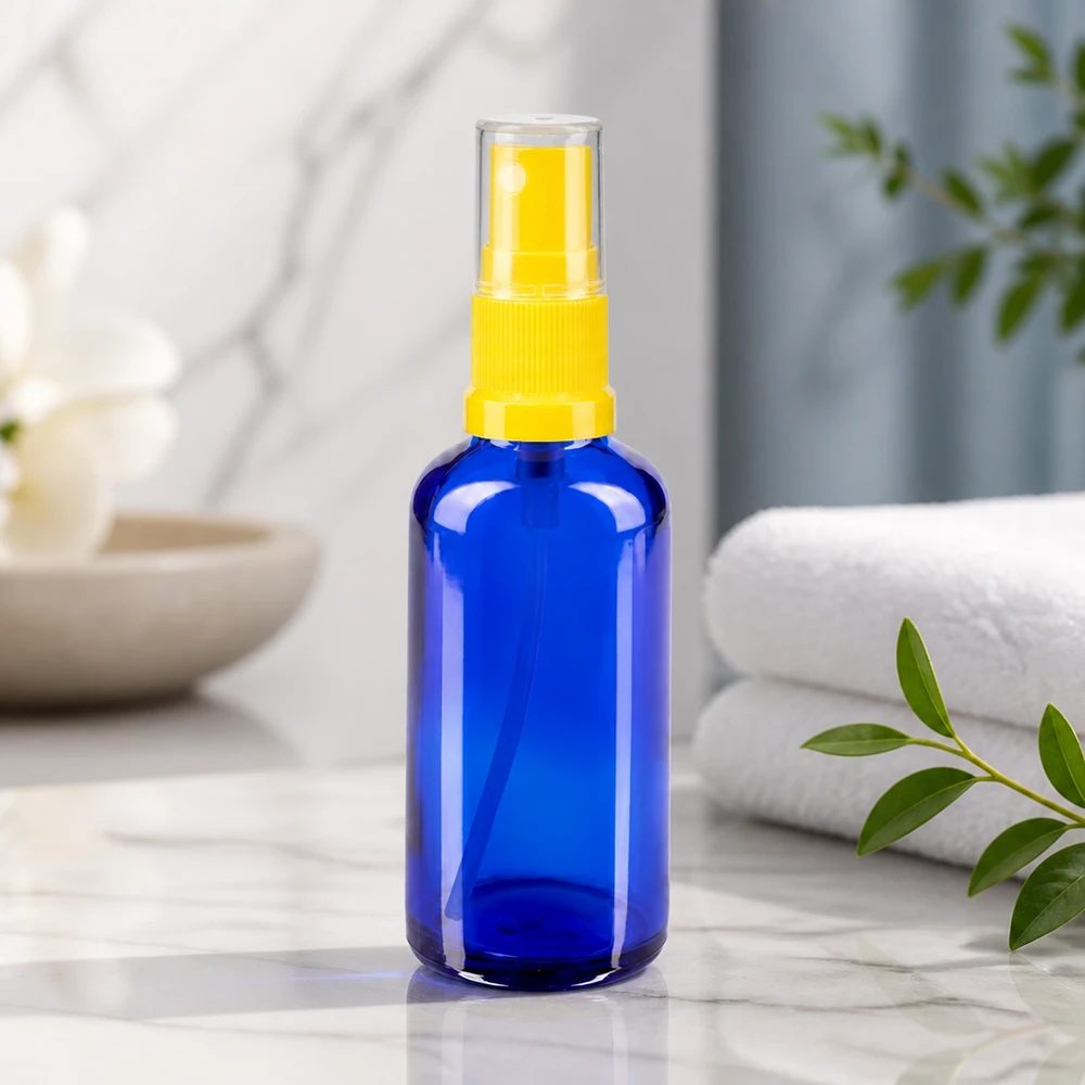 Flacon de pharmacie en verre bleu de 50 ml avec vaporisateur jaune, posé sur du marbre