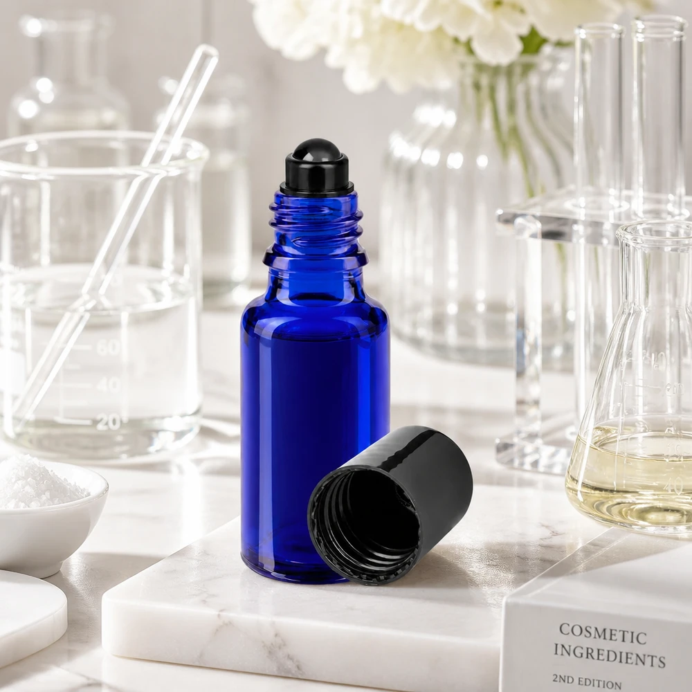Flacon de déodorant en verre bleu 20 ml, déo à bille vide Flacon roll-on de 20 ml ouvert, de couleur bleue avec un bouchon noir, posé sur un socle en marbre