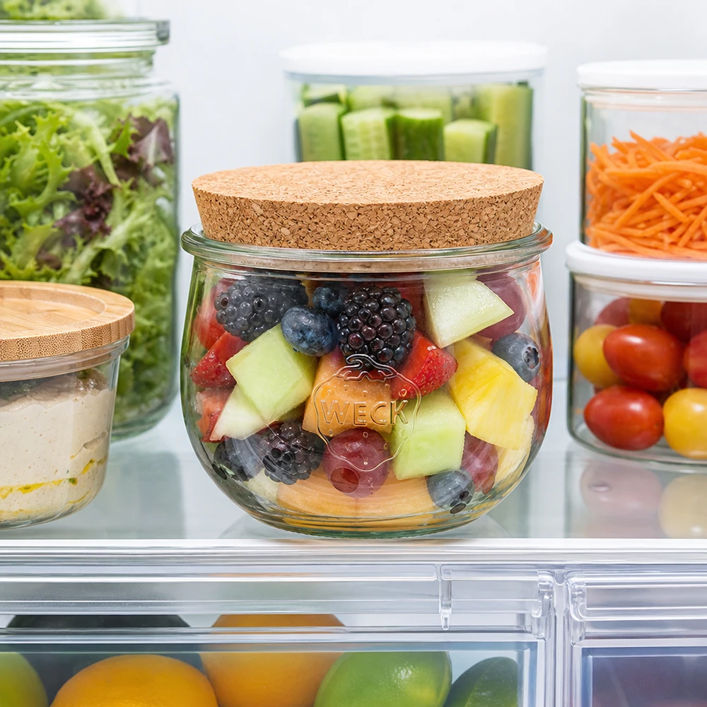 580ml bocal tulipe WECK RR100 avec bouchon nature WECK Pot tulipe 580ml avec couvercle en liège dans le réfrigérateur rempli de salade de fruits à côté d'autres bocaux de stockage avec des légumes