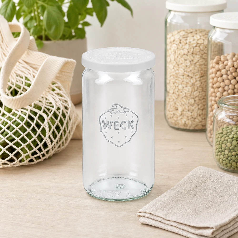 WECK Pot cylindrique 340ml vide avec couvercle fraîcheur RR60 dans la cuisine scandinave entre les bocaux à provisions et le sac en filet