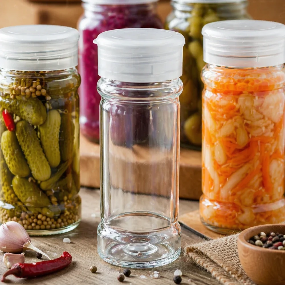 Pot à sel et à épices de 100 ml avec couvercle saupoudreur blanc, entre des légumes marinés et des concombres