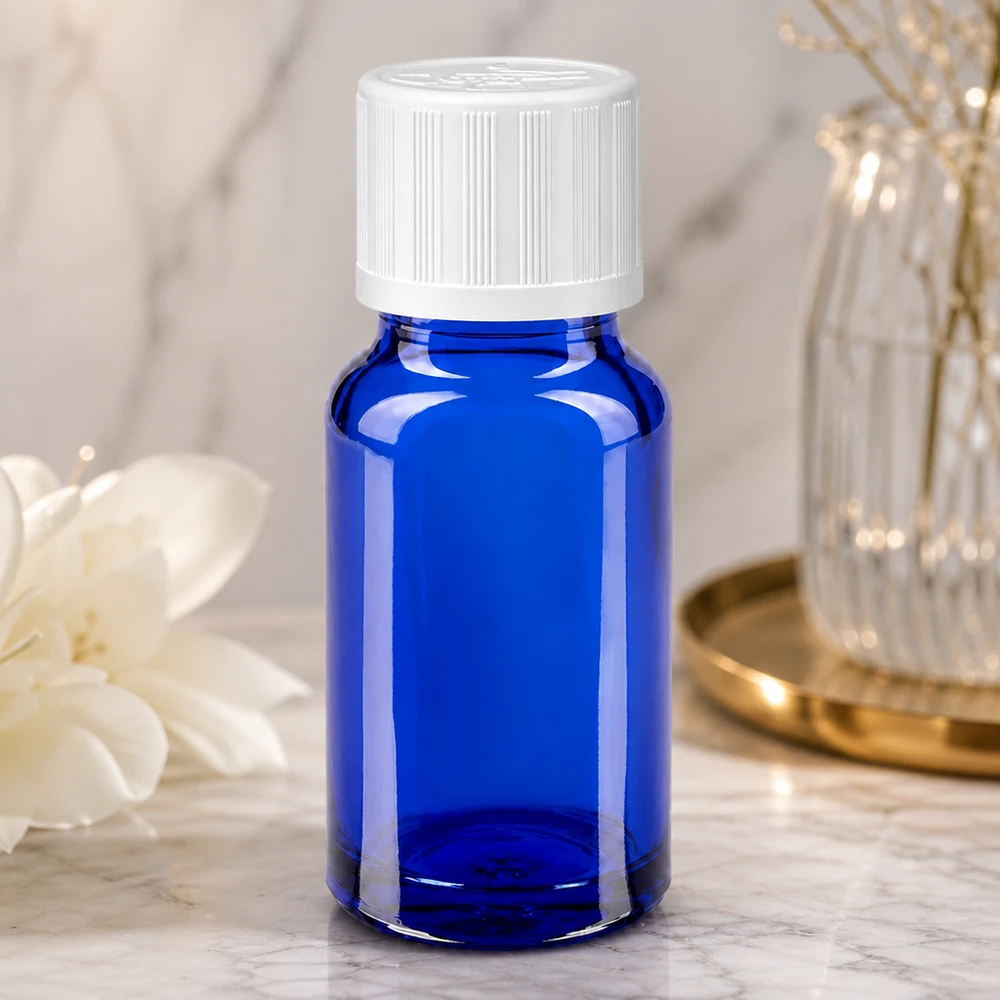 Flacon de pharmacie bleu cobalt de 10 ml avec bouchon de sécurité enfant blanc, sur fond marbré