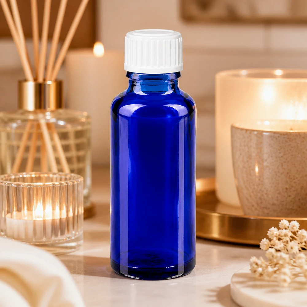Flacon de pharmacie bleu 30ml bouchon vissable blanc standard Flacon en verre bleu de 30 ml avec un bouchon blanc, entouré de bougies et de bâtonnets parfumés