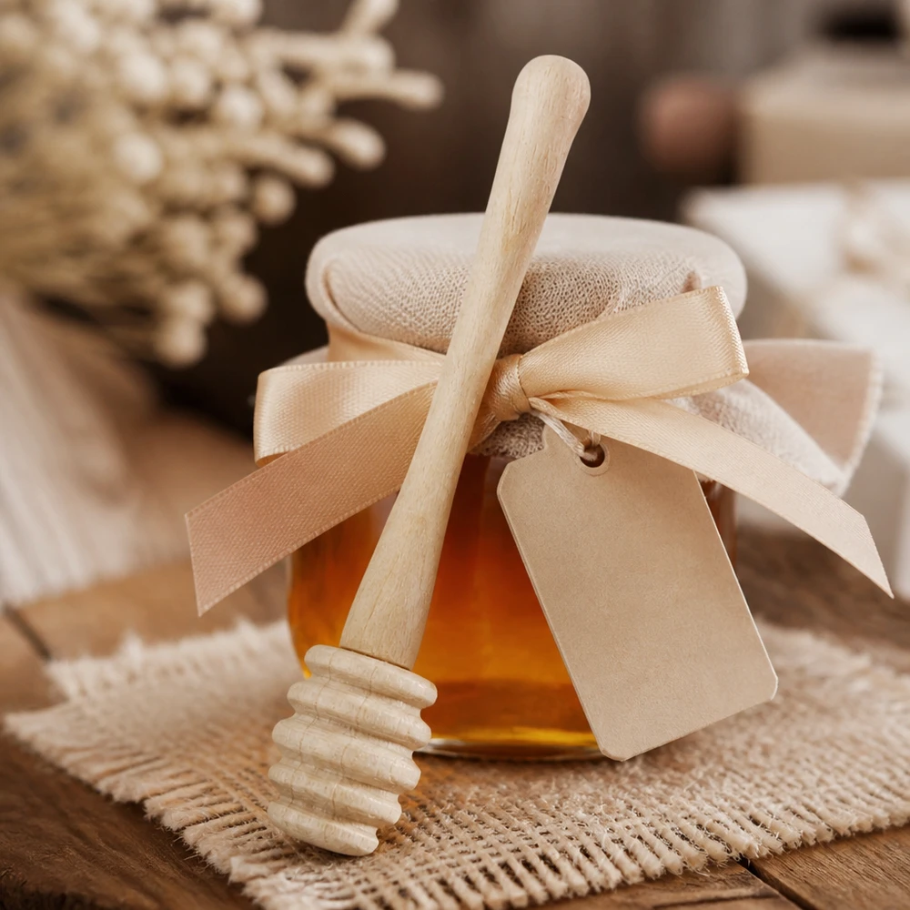 Pelle à miel en bois 10,5 cm Cuillère à miel en bois d'érable avec emballage cadeau et ruban comme cadeau à côté de rayons de miel sur fond de jute