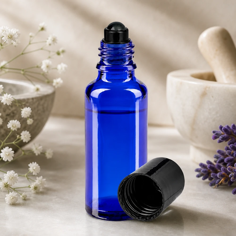 Flacon de déodorant en verre bleu 30 ml, déo à bille vide Flacon roll-on bleu de 30 ml de type pharmacie, muni d'une bille noire, à côté d'une lavande et d'un mortier
