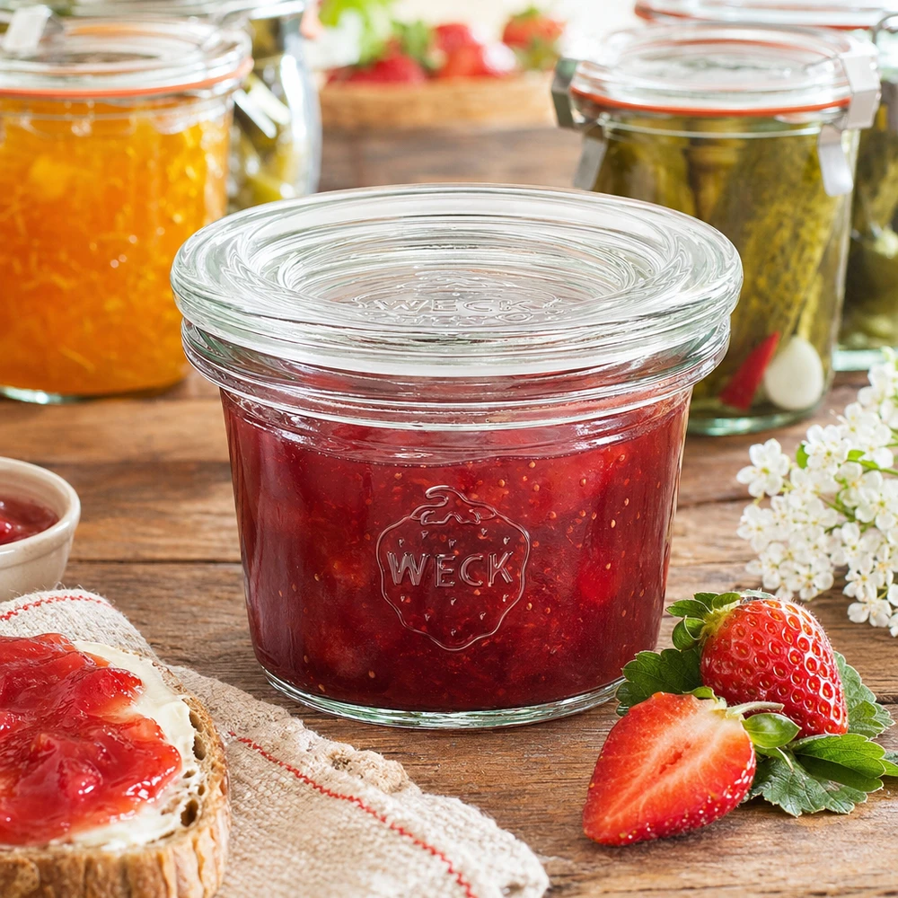 35ml bocal conique avec bouchon en verre WECK RR40 WECK Pot renversé 35ml RR40 rempli de confiture de fraises rouges à côté de fraises fraîches et de pain à la confiture