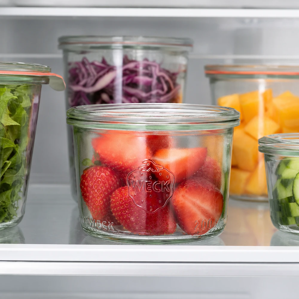 Bocal en verre à fond bombé WECK RR80 de 200 ml WECK Pot renversé 200ml RR80 avec des fraises fraîches dans le réfrigérateur à côté d'autres pots remplis de légumes et de fruits