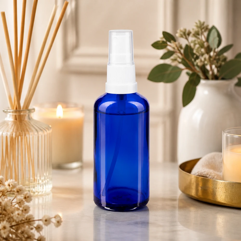 Flacon vaporisateur en verre d'apothicaire bleu de 50 ml avec pommeau transparent, dans une ambiance spa