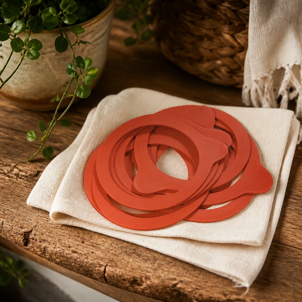 Anneaux de mise en conserve RR60 caoutchouc naturel orange sur toile de lin table rustique en bois avec plante atmosphère naturelle de cuisine