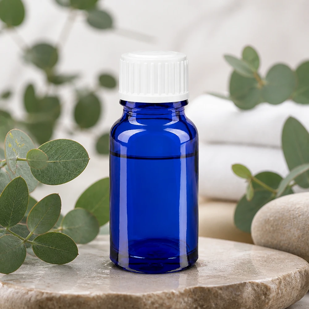 Flacon de pharmacie bleu 10ml bouchon vissable blanc standard Flacon de pharmacie bleu cobalt de 10 ml avec bouchon compte-gouttes blanc, posé sur une pierre naturelle parfumée à l'eucalyptus