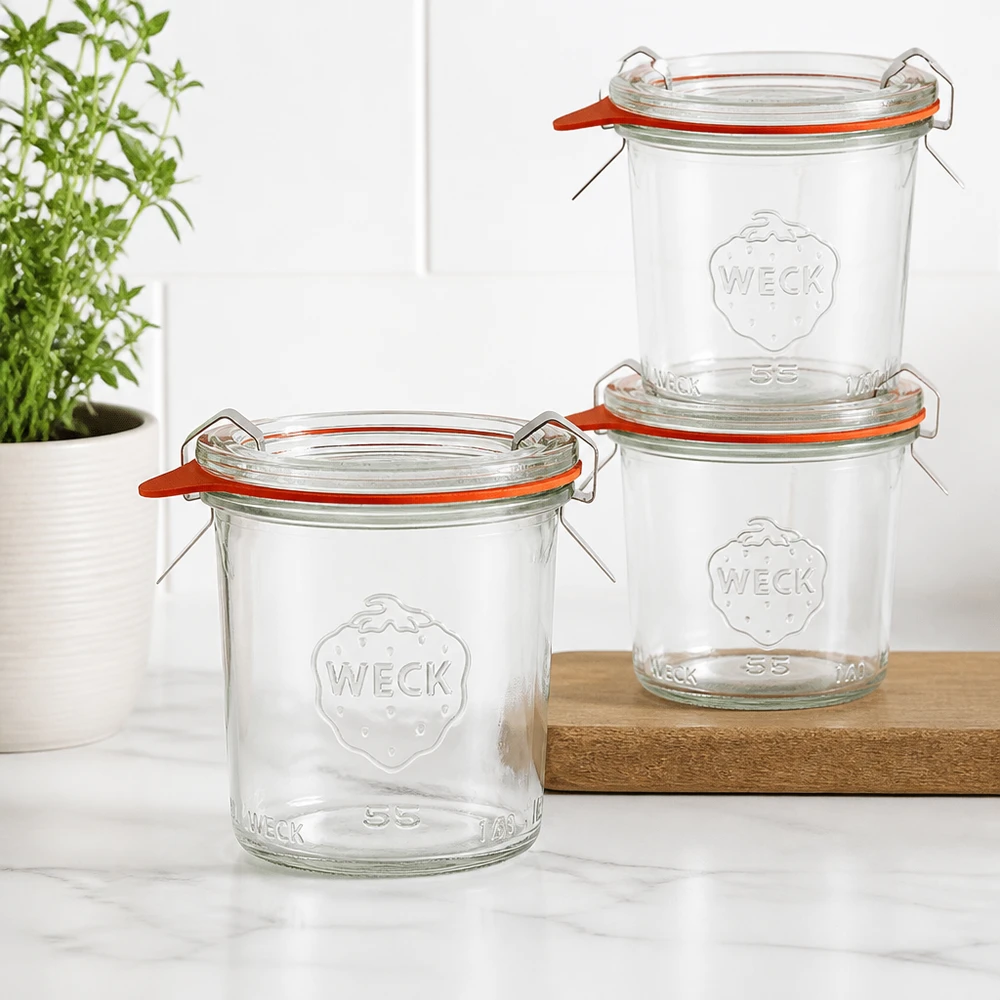 140ml bocal conique complet WECK RR60 Trois verres larmés WECK 140ml RR60 empilés sur une planche en bois dans une cuisine moderne avec une plante verte en arrière-plan
